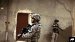 An Iraqi Army soldier and a U.S. Army soldiers from Delta Co., 1st Combined Arms Battalion, 67th Armor Regiment stand guard during a joint patrol in Mosul, Iraq, March 2009 (file photo)