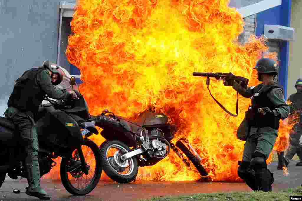 Riot security forces clash with demonstrators as a motorcycle is set on fire during a protest against Venezuelan President Nicolas Maduro&#39;s government in San Cristobal, May 29, 2017.