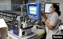 An employee of Hamilton Medical AG tests a ventilator at a plant in Domat/Ems, Switzerland March 18, 2020. REUTERS/Arnd Wiegmann