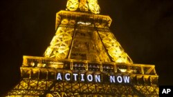 La Tour Eiffel allume avec le slogan « Passons à l'action ", se référant à la COP21 , la Conférence des Nations Unies sur les changements climatiques à Paris , le dimanche 6 décembre 2015 .