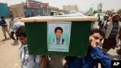 FILE - Yemeni men carry the coffin of a boy who was killed by a Saudi-led coalition airstrike, during a funeral in Saada, Yemen, Aug. 13, 2018.