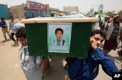 FILE - Yemeni men carry the coffin of a boy who was killed by a Saudi-led coalition airstrike, during a funeral in Saada, Yemen, Aug. 13, 2018.