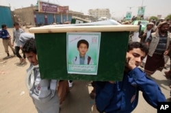 FILE - Yemeni men carry the coffin of a boy killed by a Saudi-led coalition air strike at a funeral in Saada, Yemen, on August 13, 2018.