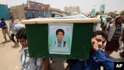 FILE - Yemeni men carry the coffin of a boy who was killed by a Saudi-led coalition airstrike, during a funeral in Saada, Yemen, Aug. 13, 2018.