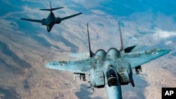 In this photo released by the U.S. Air Force, an Israeli Air Force F-15 Strike Eagle flies in formation with a U.S. Air Force B-1B Lancer over Israel as part of a deterrence flight, Oct. 30, 2021. 