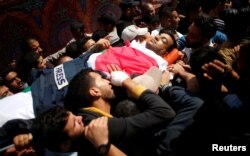 Colleagues of Palestinian journalist Yasser Murtaja, 31, who died of his wounds during clashes at the Israel-Gaza border Friday, carry his body during his funeral in Gaza city, April 7, 2018.