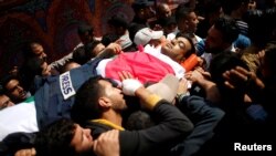 Colleagues of Palestinian journalist Yasser Murtaja, 31, who died of his wounds during clashes at the Israel-Gaza border Friday, carry his body during his funeral in Gaza city, April 7, 2018.