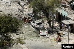 Security personnel are seen next to buildings damaged at the scene where a suicide car bomb exploded targeting a Mogadishu hotel in a business center in Maka Al-Mukaram street in Mogadishu, Somalia, March 1, 2019.