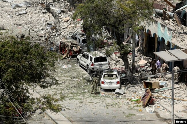 Security personnel are seen next to buildings damaged at the scene where a suicide car bomb exploded targeting a Mogadishu hotel in a business center in Maka Al-Mukaram street in Mogadishu, Somalia, March 1, 2019.
