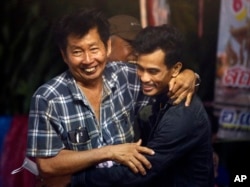 FILE - Family members hug after hearing the news that the missing 12 boys and their soccer coach have been found in the flooded cave in Mae Sai, Chiang Rai province, northern Thailand, July 2, 2018.