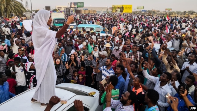 FILE - Alaa Salah, a Sudanese woman propelled to internet fame after clips went viral of her leading protest chants against President Omar al-Bashir, addresses protesters during a demonstration in front of the military headquarters in the capital Khartoum, April 10, 2019.