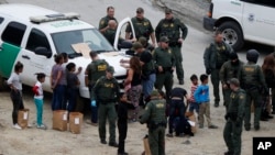 지난 10일 미국 샌디에이고 국경지대에서 국경수비대가 국경을 넘어온 온두라스 출신 이민자들의 신원을 확인하고 있다. 