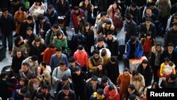 춘제 연휴를 앞두고 기차를 타기 위해 걸어가는 중국 승객들
