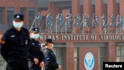 当世卫组织新冠病毒源头调查组视察武汉的中国科学院病毒研究所期间，中国保安人员在研究所外站岗。 （2021年2月3日）