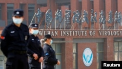 當世衛組織新冠病毒源頭調查組視察武漢的中國科學院病毒研究所期間，中國保安人員在研究所外站崗。（2021年2月3日）