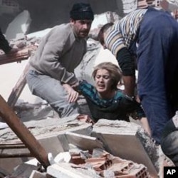 People rescue a woman trapped under debris after a powerful 7.2-magnitude earthquake struck eastern Turkey, collapsing about 45 buildings in Van province,October 23, 2011.