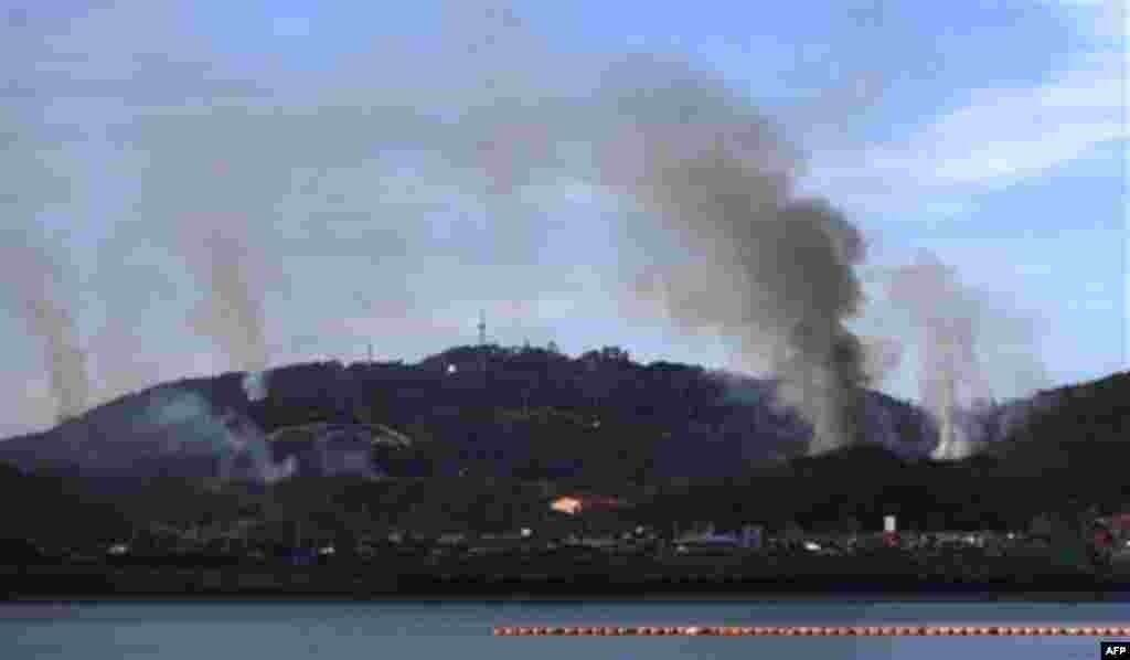 Smoke goes up from Yeonpyeong island near the border against North Korea, in South Korea, Tuesday, Nov. 23, 2010. North Korea shot dozens of rounds of artillery onto the populated South Korean island near their disputed western border Tuesday, military of