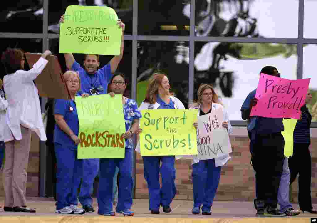 Texas Health Presbyterian Hospital Dallas staff line the drive that exits the emergency room as they wait for an ambulance carrying Nina Pham to depart, Oct. 16, 2014, in Dallas.
