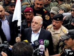 FILE - Iraqi Prime Minister Haider al-Abadi, center, raises an Iraqi flag in the city of Ramadi, 70 miles (115 kilometers) west of Baghdad, after it was retaken by the security forces, Dec. 29, 2015.