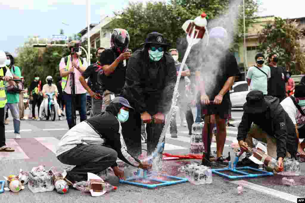 Anti-government protesters use water pressure to launch homemade projectiles during a demonstration in Bangkok, calling for the resignation of Thailand's Prime Minister Prayut Chan-O-Cha over the government's handling of the COVID-19 crisis.