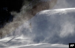 A course worker is shrouded in snow as it blows across the course where the technical events will be held before an inspection by competitors in the women's giant slalom at the Yongpyong Alpine Center at the 2018 Winter Olympics in Pyeongchang, South Korea.