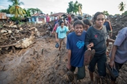 Seorang perempuan menangisi kerabatnya yang ditemukan tewas usai hujan deras membawa banjir bandang di Flores Timur, Nusa Tenggara Timur, 6 April 2021. (Foto: Antara/Aditya Pradana Putra via REUTERS)