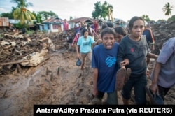 Seorang perempuan menangisi kerabatnya yang ditemukan tewas usai hujan deras membawa banjir bandang di Flores Timur, Nusa Tenggara Timur, 6 April 2021. (Foto: Antara/Aditya Pradana Putra via REUTERS)
