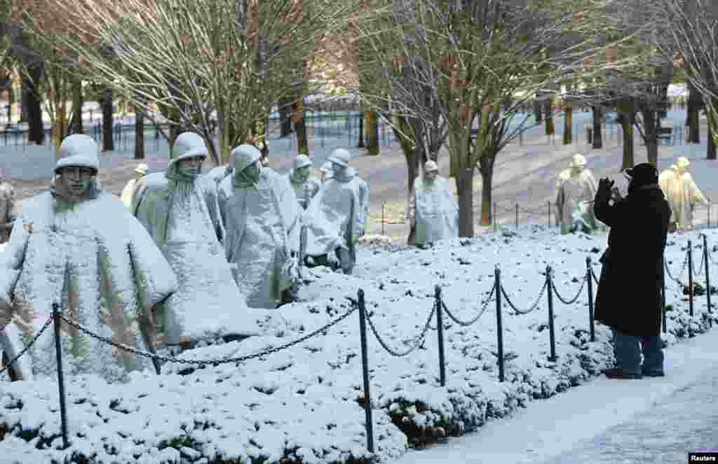 A man photographs the Korean War Veterans Memorial after a heavy snow storm in Washington D.C., Jan. 3, 2014.