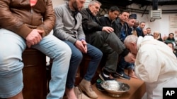 Pope Francis washes the feet of inmates during his visit to the Regina Coeli detention center in Rome, March 29, 2018. During his Holy Thursday visit, Francis stressed that a pope must serve society's marginalized and give them hope. 