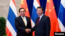 Thailand's Prime Minister Prayuth Chan-ocha (L) shakes hands with China's President Xi Jinping before a meeting at the Great Hall of the People in Beijing, December 23, 2014.