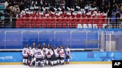 North Korea fans, top, wave the Korean unification flag as players of a combined Koreas team gather at the end of a women's hockey game against Switzerland, at the 2018 Winter Olympics in Gangneung, South Korea, Feb. 10, 2018.