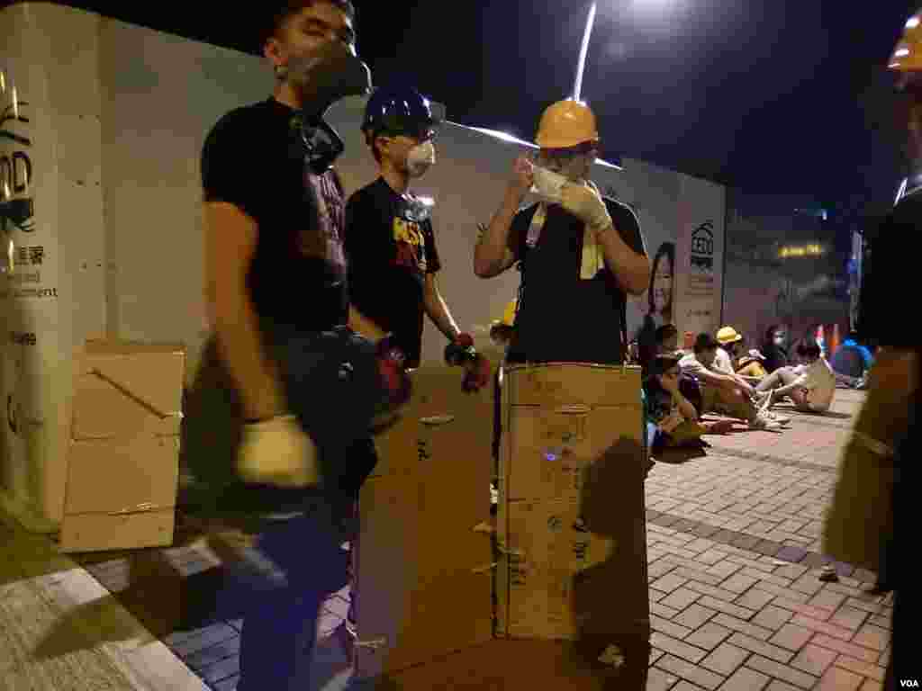 參與包圍政府總部的示威者阿賢（左一）表示，與同伴準備了紙盾牌防禦警員以 警棍擊打