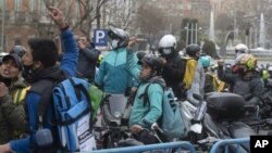 Delivery riders protest outside the Spanish parliament in Madrid, Wednesday March 3, 2021.The Spanish government announced on Thursday March 11, 2021, legislation that classifies food delivery riders as employees of the digital platforms they work for, no