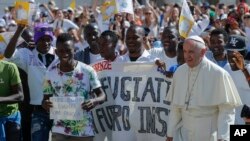 Le pape François marche avec un groupe de réfugiés qu'il a invité à le joindre à la Basilique de Saint-Pierre au Vatican le 22 juin 2016.