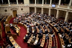 Greek lawmakers attend an emergency parliament session for the government’s proposed referendum in Athens, June 27, 2015.