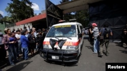 An ambulance carrying the bodies of those killed in the fire exits the Virgen de Asuncion home, in San Jose Pinula, on the outskirts of Guatemala City, Guatemala, March 8, 2017. 