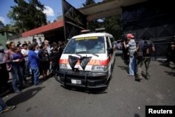 An ambulance carrying the bodies of those killed in the fire exits the Virgen de Asuncion home, in San Jose Pinula, on the outskirts of Guatemala City, Guatemala, March 8, 2017.