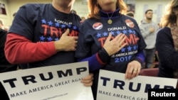FILE - Supporters of U.S. Republican presidential candidate Donald Trump hold their hands to their chest as the national anthem is played at a campaign rally in Concord, New Hampshire, Jan. 18, 2016. As the only Republican left in the field, Trump has now all but clinched the Republican party's nomination.