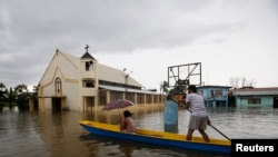A man ferries a passenger on a boat past a church along a flooded road brought by moonsoon rains and reinforced by tropical storm Trami, in Calumpit, Bulacan, north of Manila, August 21, 2013. 