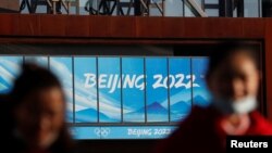 戴着口罩的人们在北京2022年冬奥会和冬残奥会组委会办公大楼附近（资料照片）
