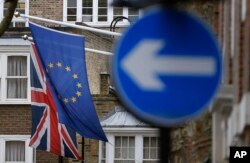 An EU flag hangs beside the Union flag in London, Feb. 17, 2016. (AP)
