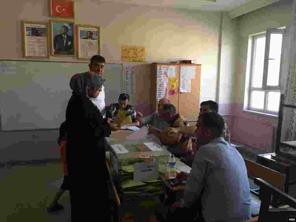 A woman turns in her ballot at a polling station in Gaziantep, Turkey, June 7, 2015. (Mutlu Civiroglu/VOA)