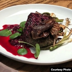 A dish created by Lakota "Sioux Chef" Sean Sherman, which features elk, wild rice, fern fiddlehead, berries, spring onion and sunchoke.