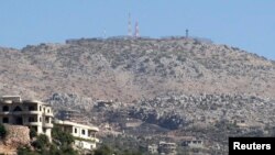 FILE - A view shows an Israeli position as seen from the Lebanese village of Kfar Shouba near the Lebanese-Israeli border, southern Lebanon, Oct. 7, 2014. 