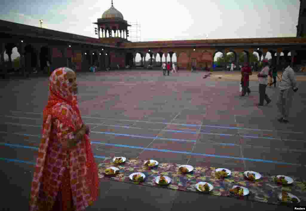 Seorang perempuan menunggu makanan berbuka puasa di Jama Masjid, New Delhi.&nbsp; 