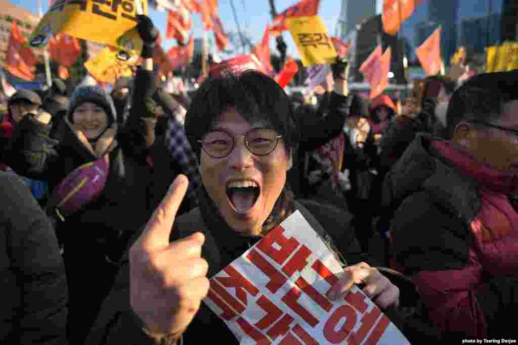 A protester reacts after the South Korean parliament&#39;s successful impeachment of President Park Geun-Hye as crowds gather outside the National Assembly in Seoul. Lawmakers began voting on an impeachment motion to strip the president of her sweeping executive powers over a corruption scandal that has paralyzed her administration and triggered massive street protests.