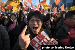 FILE - A protester reacts after the South Korean parliament's successful impeachment of President Park Geun-Hye as crowds gather outside the National Assembly in Seoul, Dec. 9, 2016.