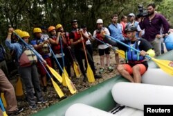 Duberney Moreno, former rebel of the FARC, rafting guide and instructor, speaks with a group of the press and government representatives before boarding an inflatable raft in Miravalle, Colombia, Nov. 9, 2018.