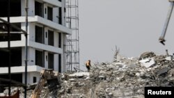 FILE: A rescue member works on the debris as search and rescue efforts continue at the site of a collapsed building in Ikoyi, Lagos, Nigeria Nov. 2, 2021.