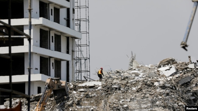 FILE: A rescue member works on the debris as search and rescue efforts continue at the site of a collapsed building in Ikoyi, Lagos, Nigeria Nov. 2, 2021.